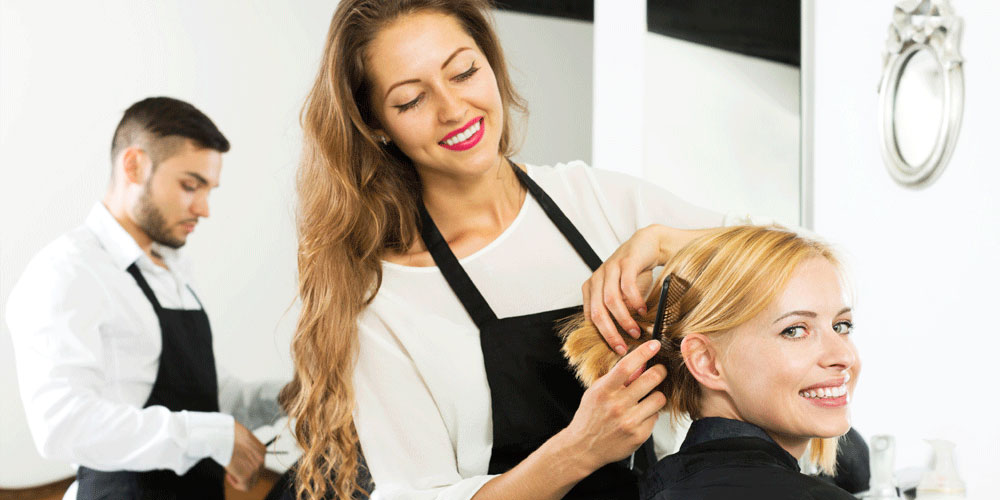 Cabeleireiro profissional fica em um salão de beleza com um